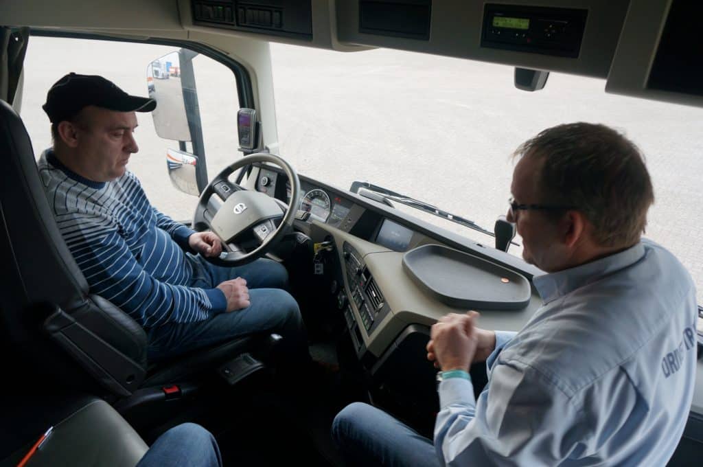 Een chauffeur krijgt bijscholing in een vrachtwagen